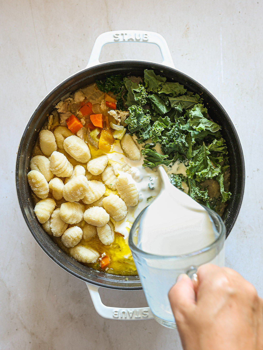 gnocchi and kale in a pot with vegetables.