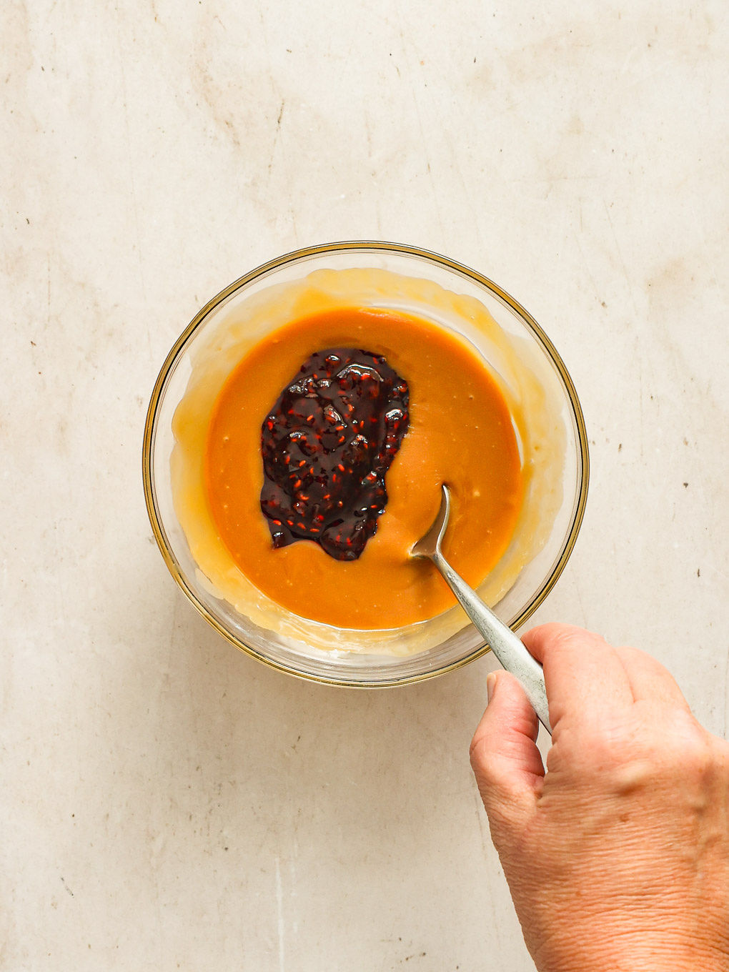 melted caramels with raspberry preserves in a bowl.